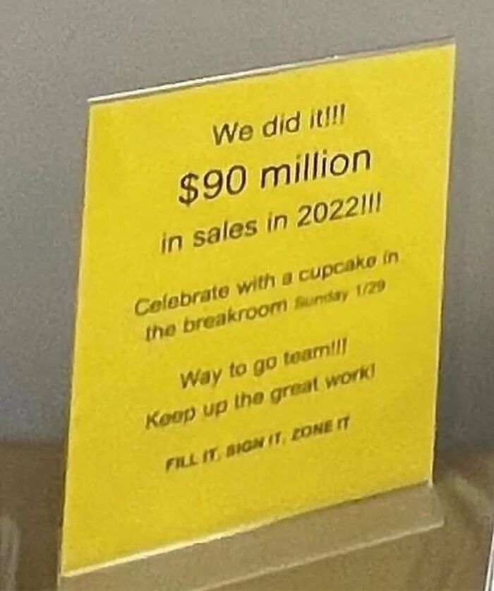 Yellow sign celebrating 90 million in sales in 2022 in office breakroom
