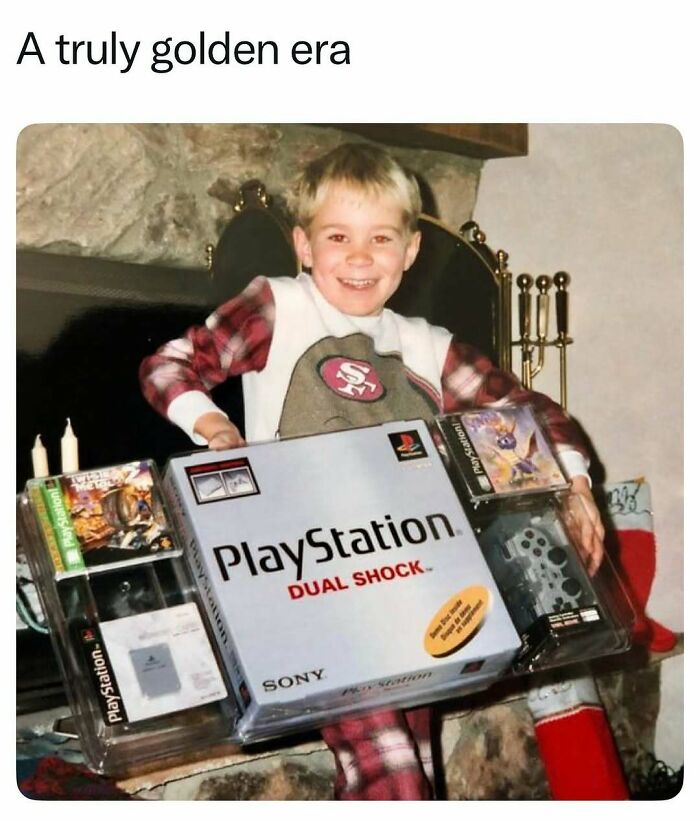 Boy excitedly holding a PlayStation Dual Shock console from the 1990s golden era