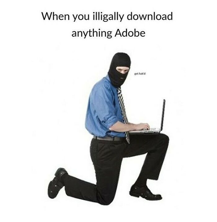 A person in a balaclava kneeling with a laptop, representing the act of illegally downloading Adobe, a moment of design humor.