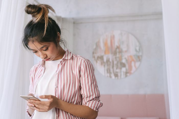 A young woman, representing Gen Z, absorbed by her smartphone, highlighting the concern of dopamine sites and new trend. A young woman, representing Gen Z, absorbed by her smartphone, highlighting the concern of dopamine sites and new trend.