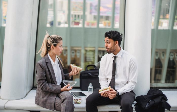 Two young professionals having lunch outdoors, discussing the dark side of dopamine sites. Two young professionals having lunch outdoors, discussing the dark side of dopamine sites.