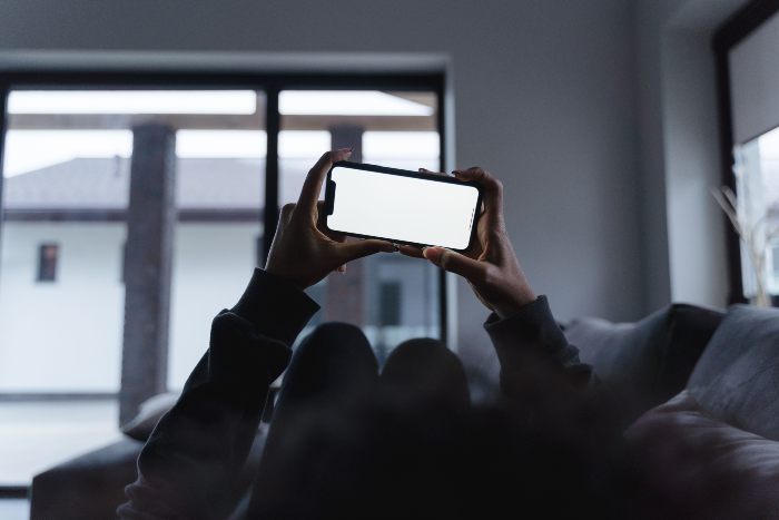 A person holding a smartphone with a blank screen, symbolizing engagement with dopamine sites. A person holding a smartphone with a blank screen, symbolizing engagement with dopamine sites.