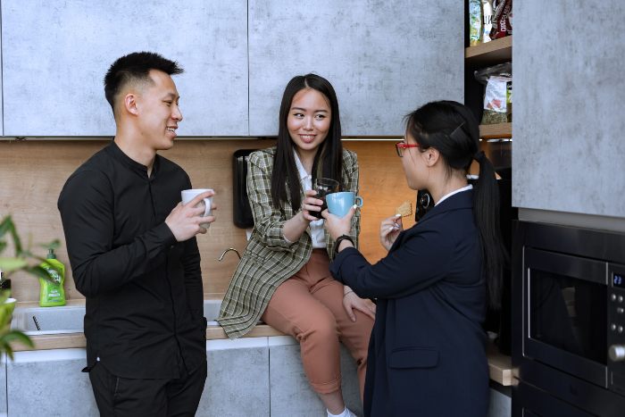 Three young adults in a modern kitchen, likely discussing the new trend of dopamine sites. Three young adults in a modern kitchen, likely discussing the new trend of dopamine sites.