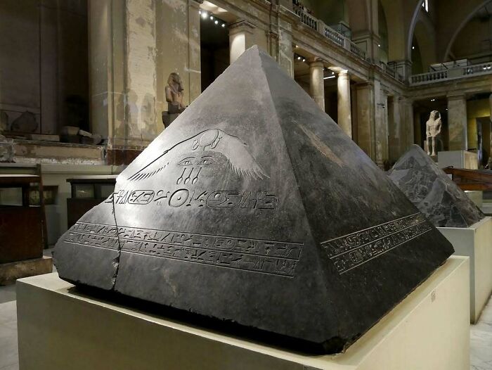 Ancient Egyptian pyramidion with hieroglyphs displayed as historical treasure