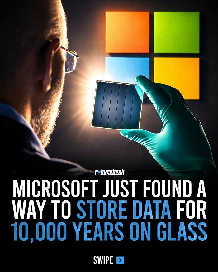 A man looking at a data storage device on glass, a future technology for storing data.