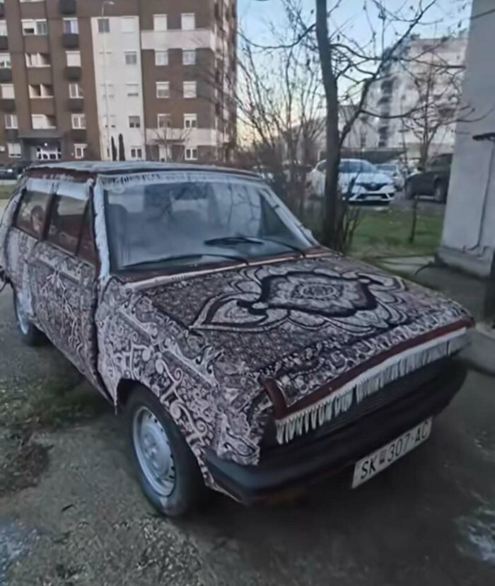 Small car covered with patterned carpet exterior