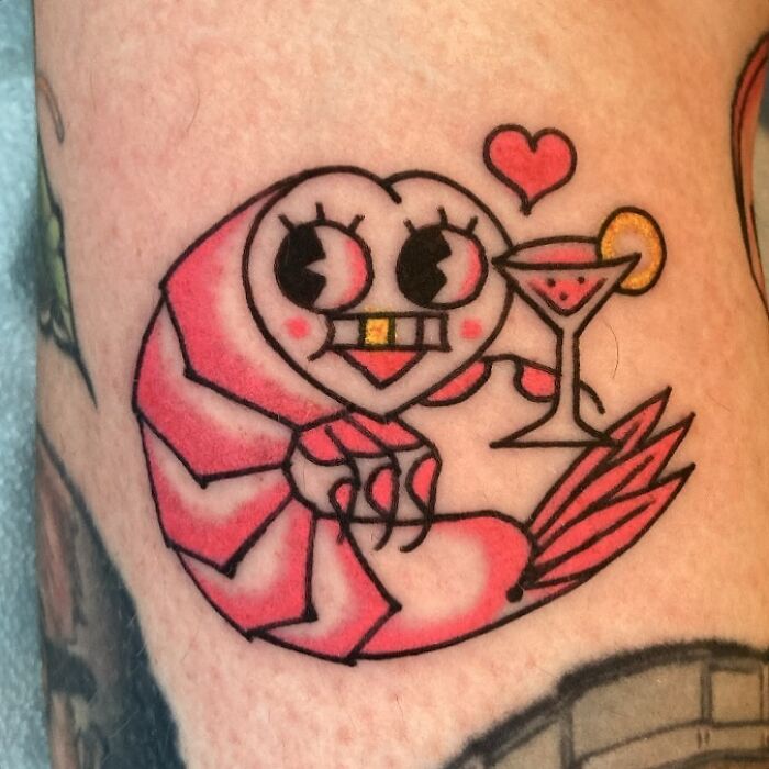 A tattoo artist's talent is used to create a shrimp holding a martini tattoo on a leg, a questionable idea.