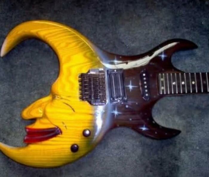 Electric guitar with a cursed moon face design and starry pattern