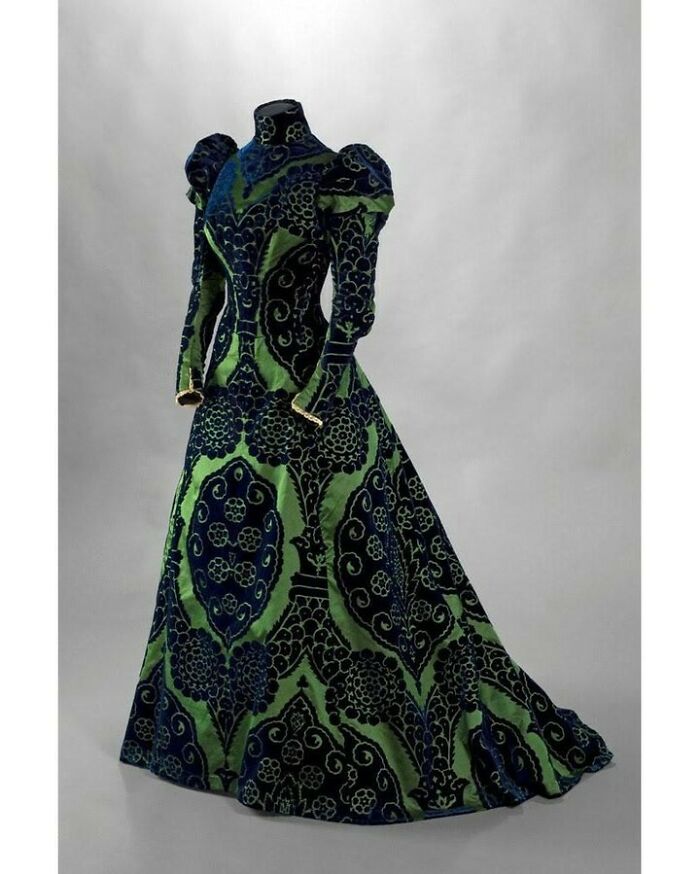 Victorian era blue and green patterned gown displayed on mannequin