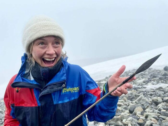 Person excitedly holding ancient spear artifact found in archaeological site
