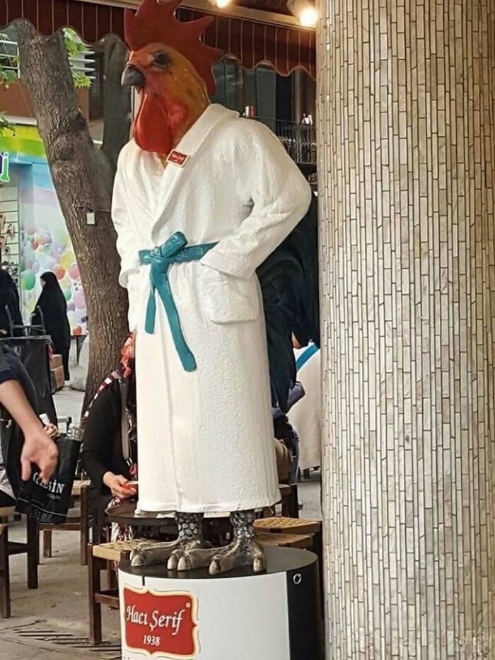 Rooster statue wearing a bathrobe on display in cursed images gallery