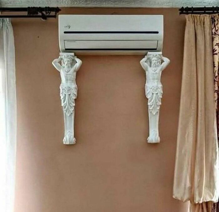 Cursed image of air conditioner supported by two carved statues on wall