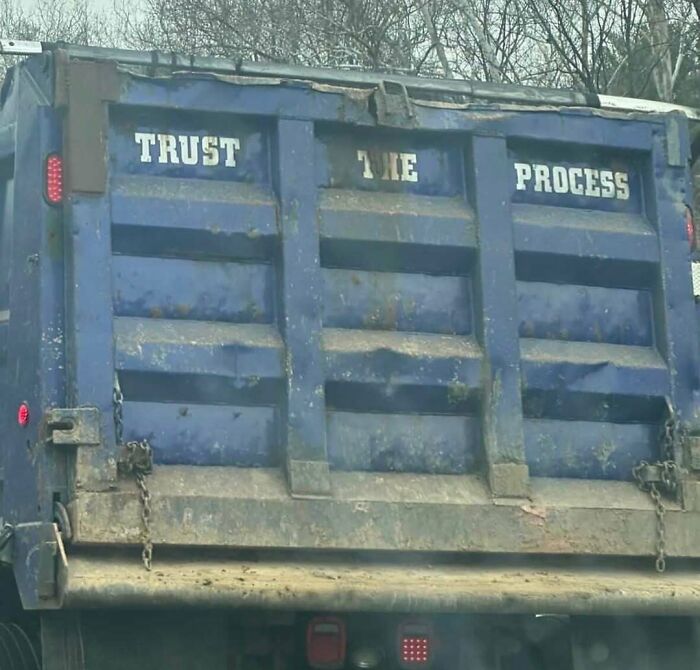 Blue rusty truck with trust the process text on back