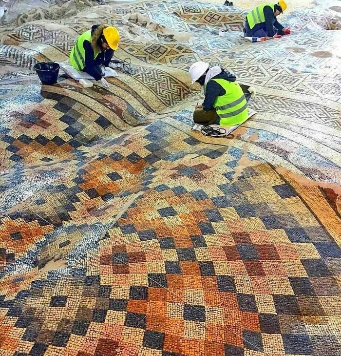 Archaeologists restoring large colorful ancient mosaic historical treasure