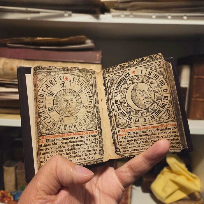 Old miniature book with intricate illustrations historical treasure in hand