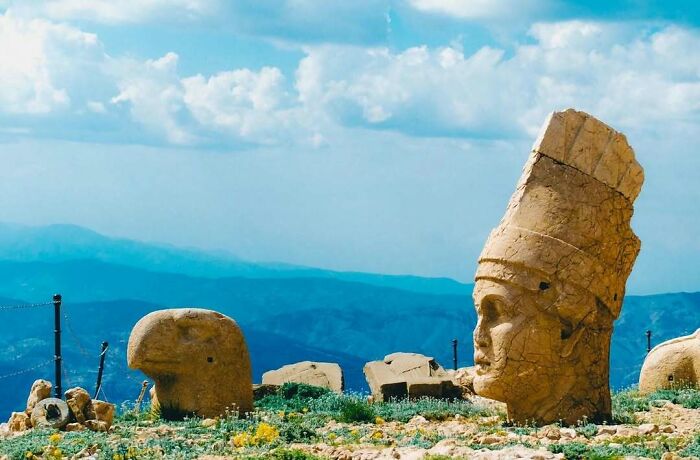 Gigantic stone head ruins with mountain backdrop historical treasure