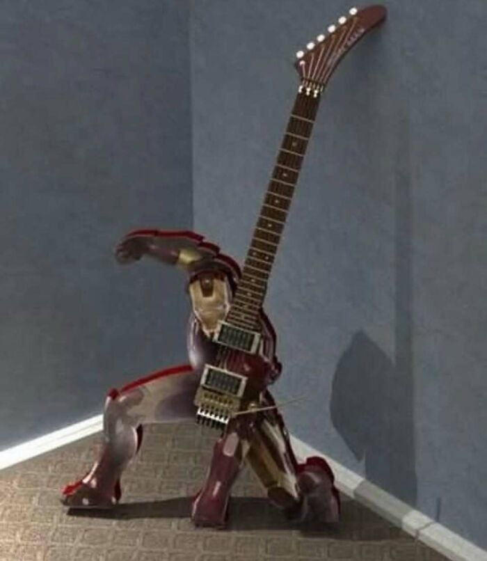 Iron Man figure holding a guitar in a dramatic pose in a corner