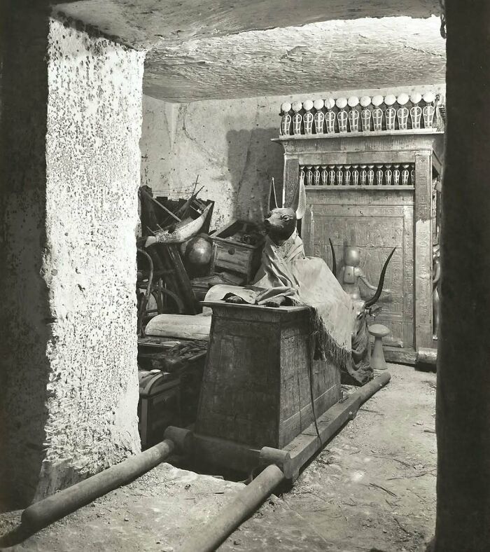 Black and white photo of an Egyptian tomb with sarcophagus and burial artifacts