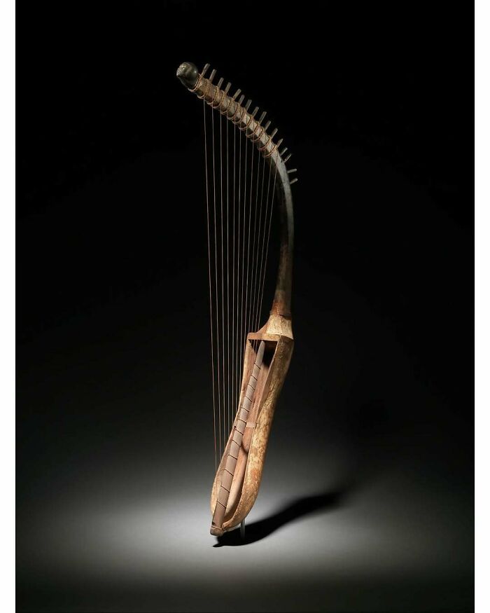 Ancient wooden harp historical treasure with strings on dark background