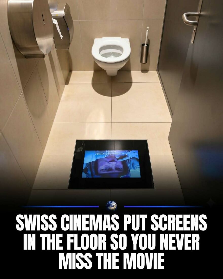 A unique bathroom with a screen on the floor, showcasing human creativity in modern cinema and public spaces.
