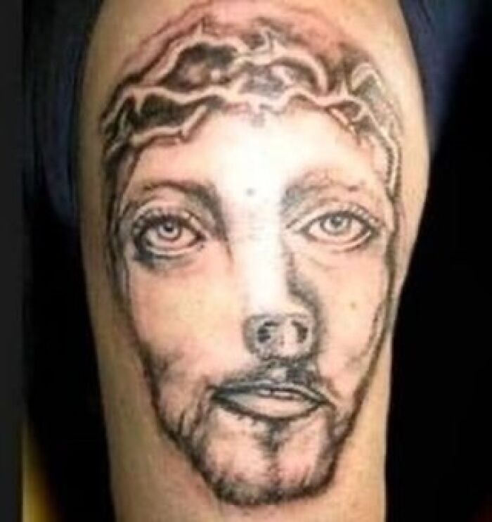 Cursed tattoo of a distorted face on a person's arm