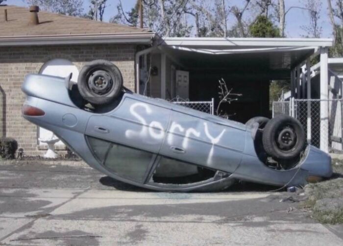 Cursed image of a flipped car with the word sorry spray painted on side