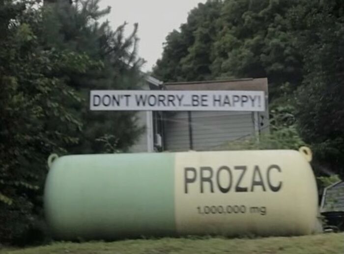Huge Prozac pill outdoor sculpture with sign saying dont worry be happy