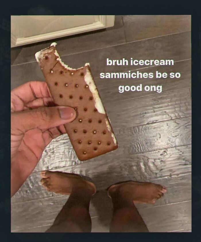 A person holding a bitten ice cream sandwich with bare feet visible below, one of many chaotic and unhinged pics.