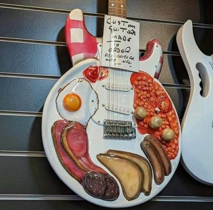 Custom guitar with breakfast food 3D art including eggs, sausages, and beans on its body