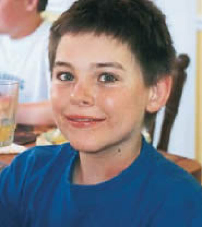 Young boy with short brown hair and blue eyes, smiling. An image from a solved mystery.