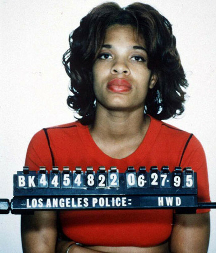 A mugshot of a woman with dark hair and red lipstick, part of a collection of celebrity scandals.
