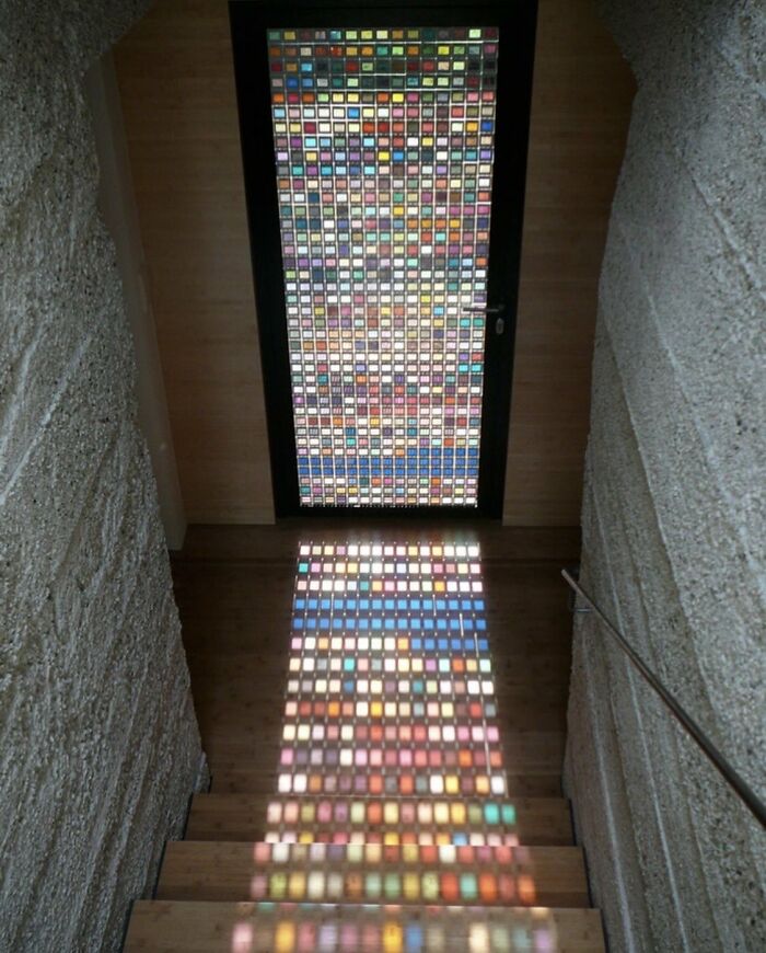 Colorful stained glass door casting patterned light on stairs