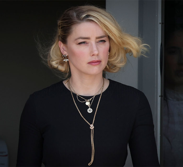 Close-up of Amber Heard with a serious expression, reflecting on her new life in a new country. Close-up of Amber Heard with a serious expression, reflecting on her new life in a new country.