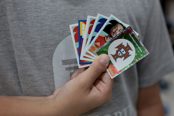 Hand holding multiple World Cup soccer player stickers