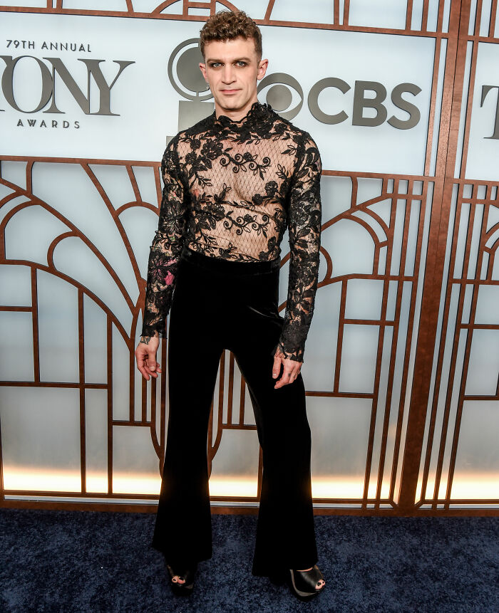 Person in black floral lace top and velvet pants at 2026 Tony Awards red carpet