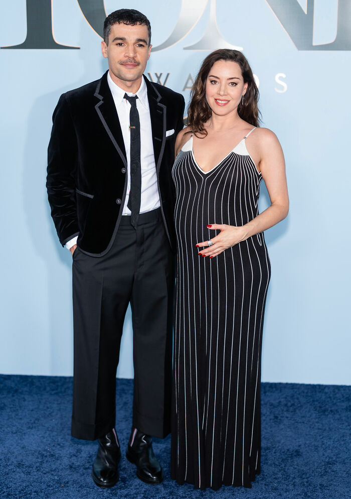 Couple posing on red carpet in formal black attire at Tony Awards
