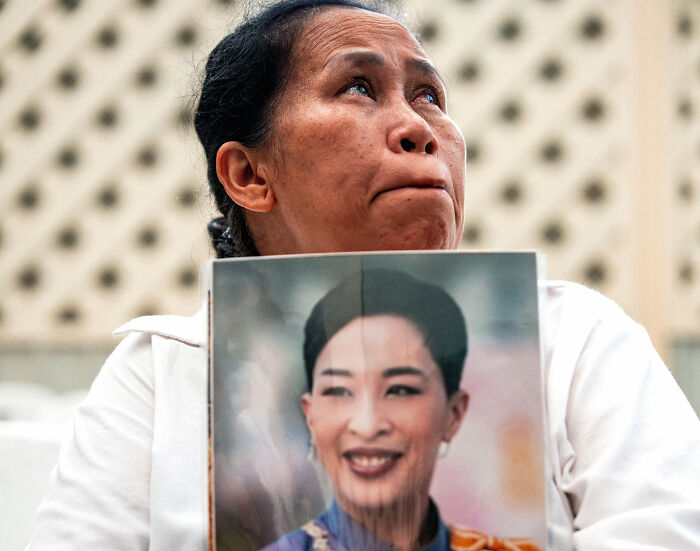 Woman holding photo of Thai princess with emotional expression Woman holding photo of Thai princess with emotional expression