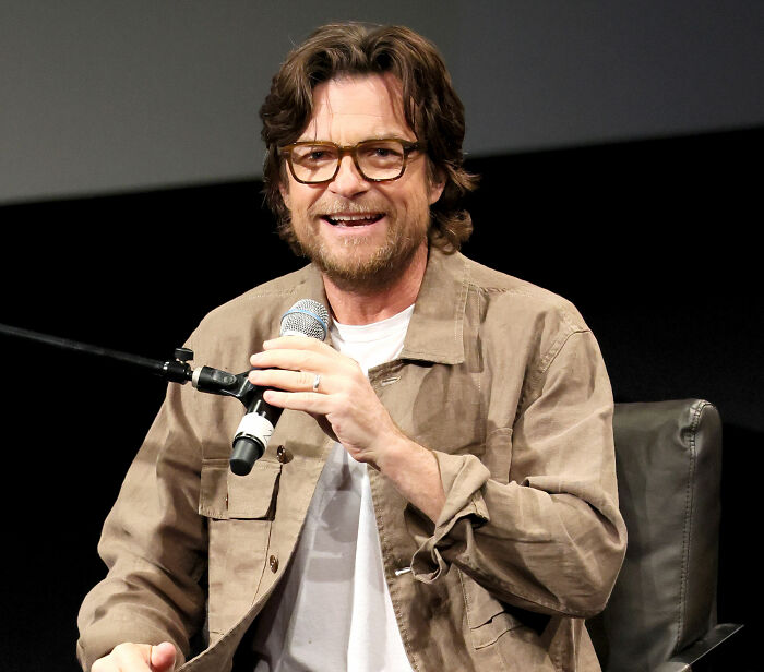 Jason Bateman smiles, wearing glasses and a brown jacket, holding a microphone. He discusses ex Amy Poehler with Will Arnett. Jason Bateman smiles, wearing glasses and a brown jacket, holding a microphone. He discusses ex Amy Poehler with Will Arnett.