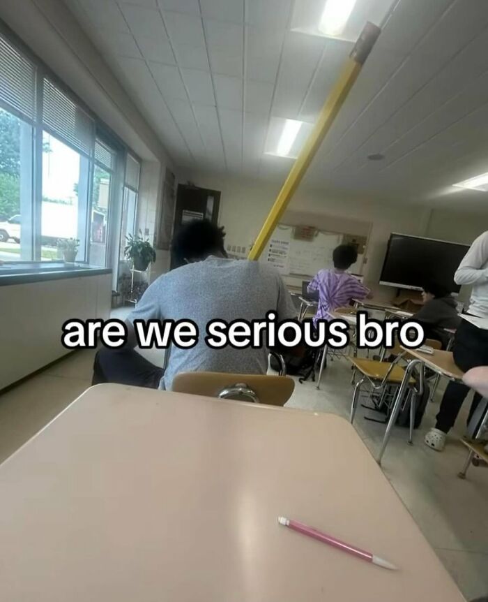 A cringe classroom scene with a student holding an impossibly large pencil, making a ridiculous statement.