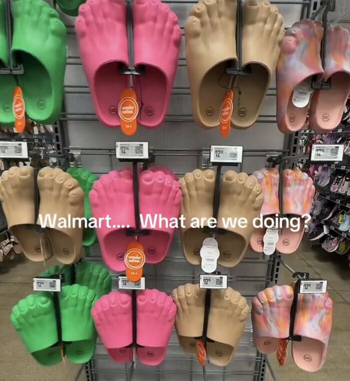 A display of cringe novelty foot-shaped slide sandals in various colors at Walmart, prompting the question, Walmart.... What are we doing?