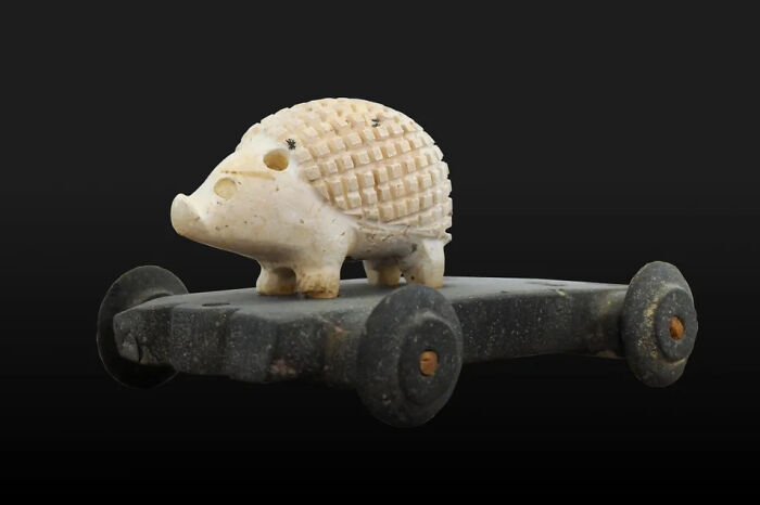 An ancient hedgehog sculpture on wheels, an interesting object still intact after all these years, highlighting historical toys.