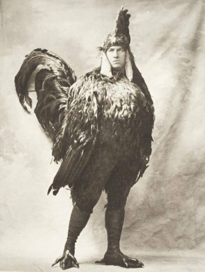 A person in a large, vintage rooster costume, one of many intact objects from the past.