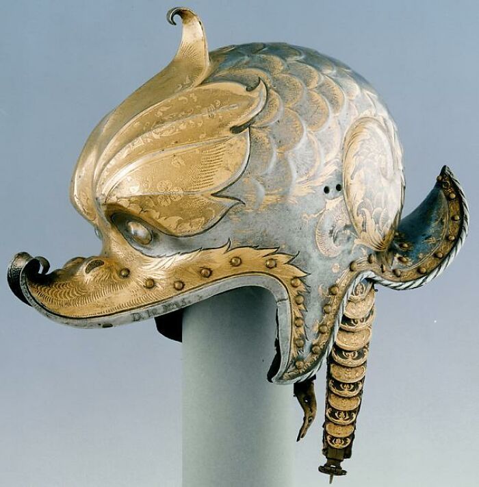 An ornate, vintage helmet with gold engravings, an intact object showcasing historical craftsmanship.