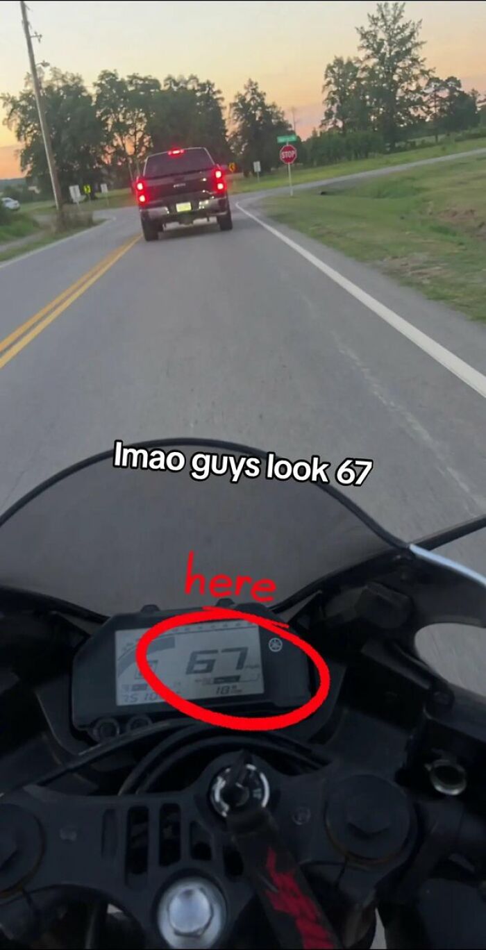A view from a motorcycle dashboard showing the speed at 67 mph, a cringe moment. A truck is ahead on the road.
