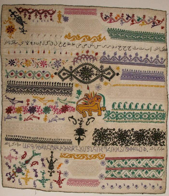 A finely detailed, vintage embroidered textile with various patterns and a central lion motif, an intact object.