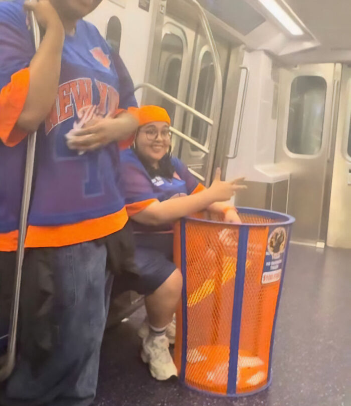 A person in a Knicks jersey with a stolen Knicks trashcan on a subway, showcasing the JPMorgan exec's actions. A person in a Knicks jersey with a stolen Knicks trashcan on a subway, showcasing the JPMorgan exec's actions.
