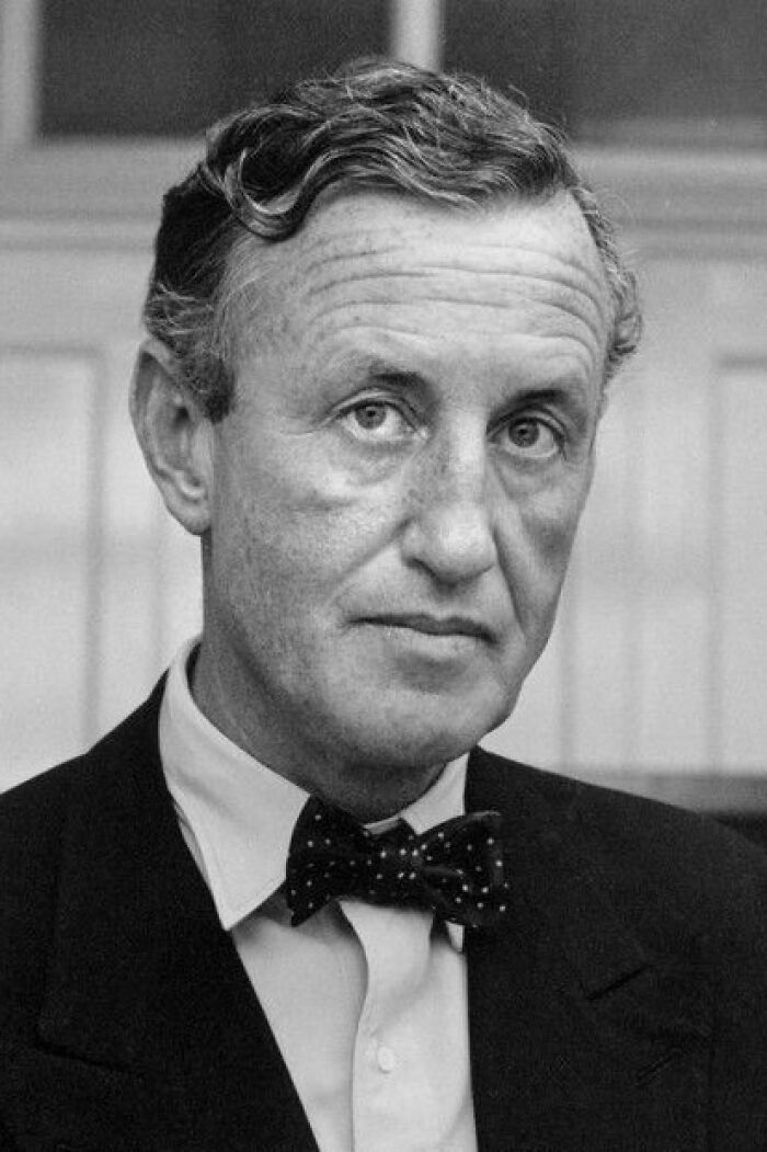 A black and white portrait of a man in a suit and bow tie, reflecting on cool and interesting facts.