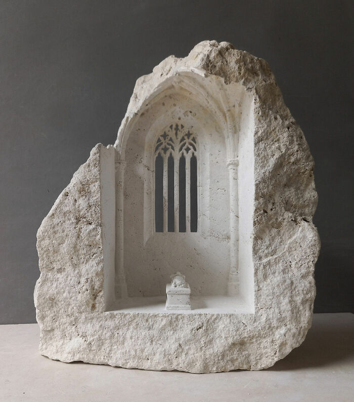 Artist carves tiny architectural models of ancient buildings with intricate window details into solid stone.