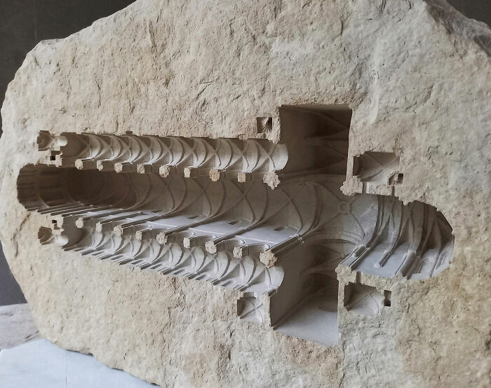 Artist carves tiny architectural models of classical buildings into solid stone, revealing a carved interior cross-section.