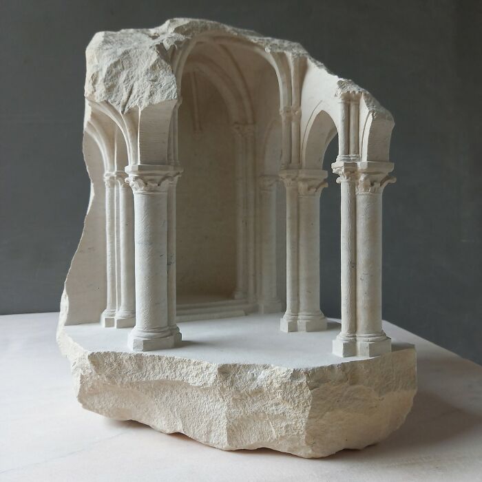 Artist carves tiny architectural models of ancient buildings into solid stone, revealing a detailed interior with columns.